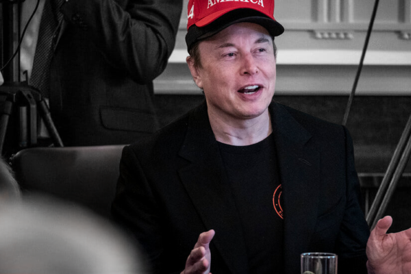 Ілон Маск на фоні Tesla